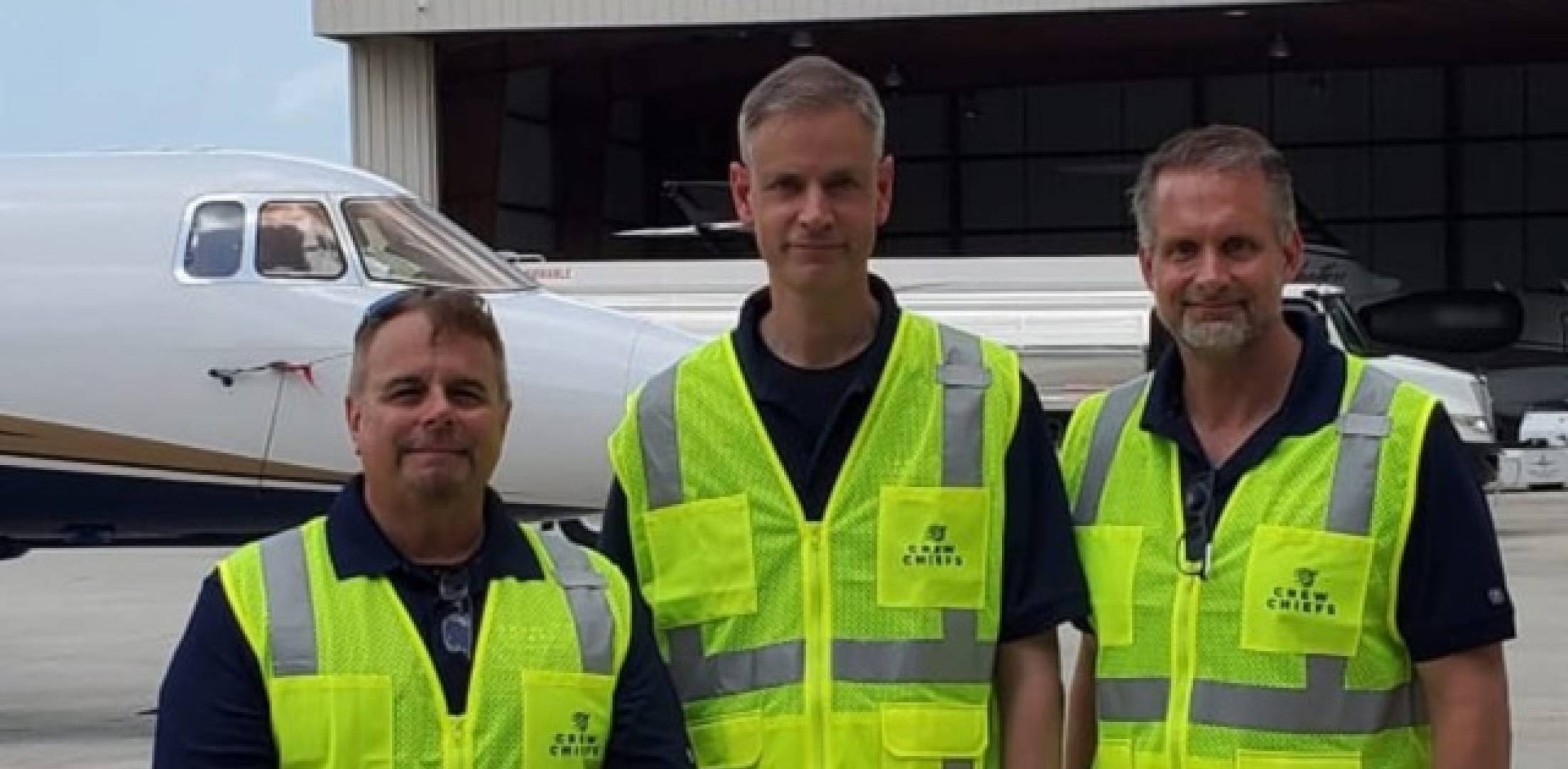 Crew Chiefs company founders in hi-vis vests in front of business aircraft