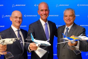 3 men holding airplane models