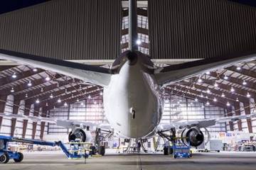 Tail view of airliner parked in AAR maintenance hangar