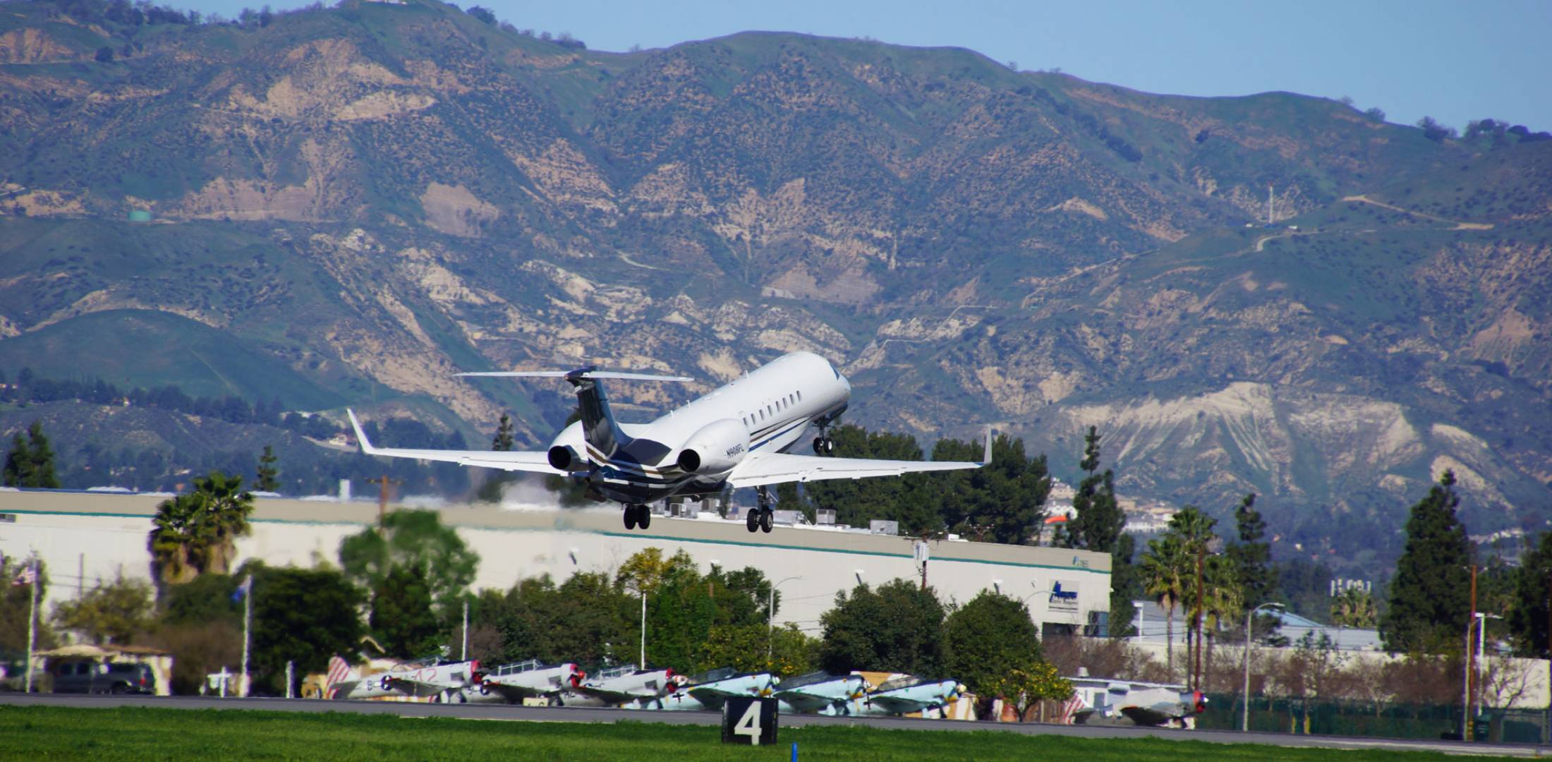 Business jet taking off from airport near mountains 