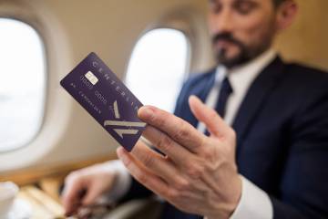 Businessman on jet holding Priester Aviation's Centerline jet card