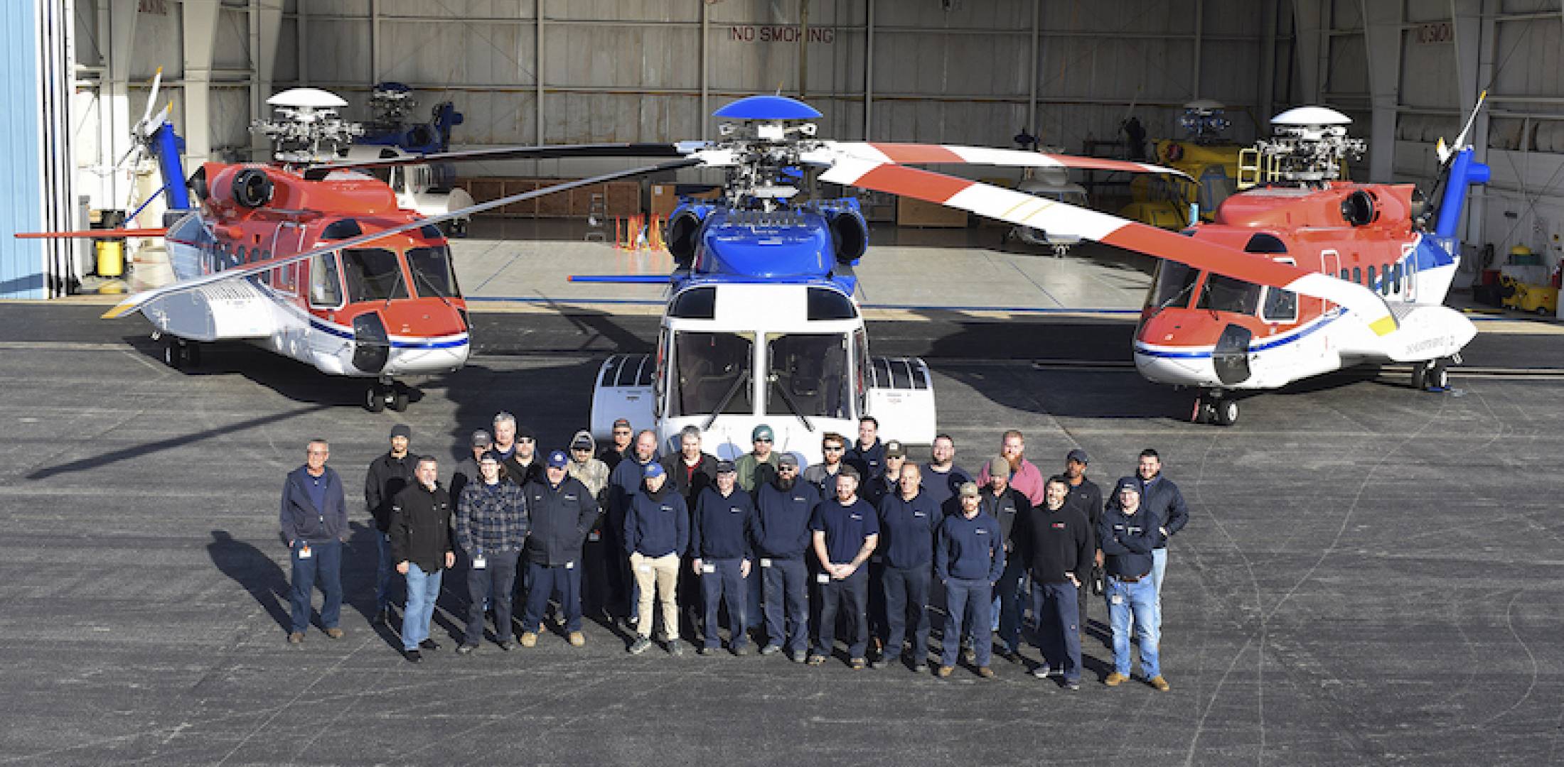 Photo of Summit Aviation team and helicopters outside hangar