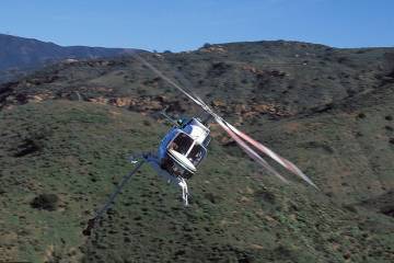 Bell 407 owned by Volusia County Sheriff's Department in flight over mountainous terrain