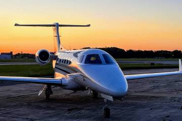 GrandView Aviation Phenom 300 business jet parked on airport ramp at sunset